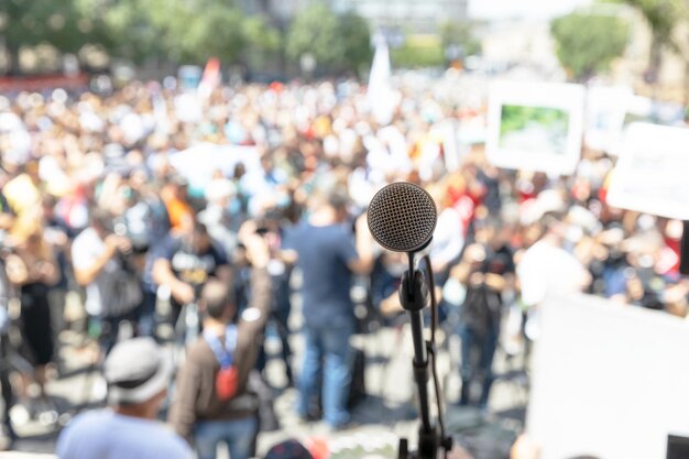 Foto focus sul microfono sfocato gruppo di persone alla protesta sullo sfondo