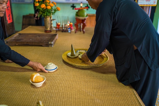 Focus old man with traditional Vietnamese dress prepare lunch for lunar new year this relic is also known as Ong Tran temple A place of worship for Confucius