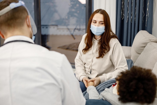 Focus op een moeder die met een mannelijke kinderarts praat over haar zieke kleine meisje