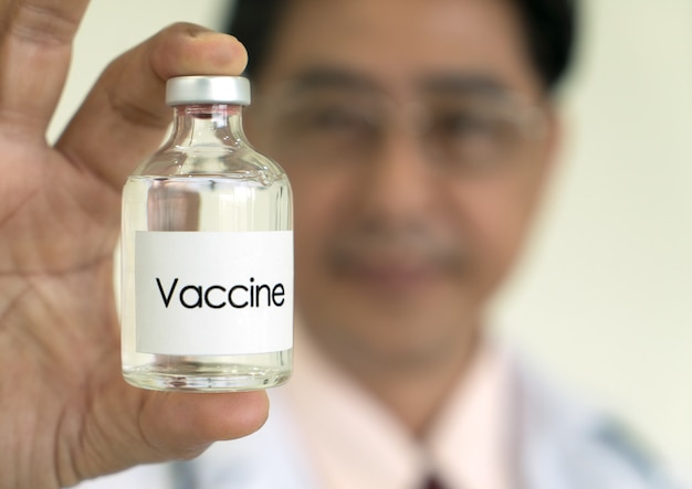 Focus op een vaccin in de hand van de dokter Coronavirus Covid19 concept