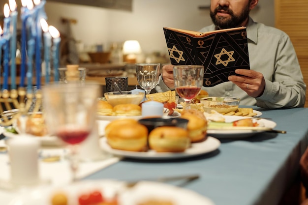 Focus op geknipte volwassen man die torah leest in zwarte omslag met een ster van david