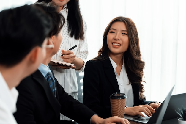 흐릿한 동료 수치가 조화를 이루는 아시아 여성 관리자의 초점 초상화