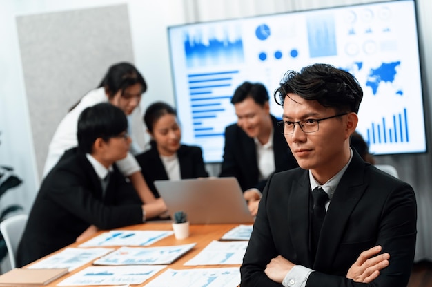 Focus portrait male manager in harmony office with businesspeople in background