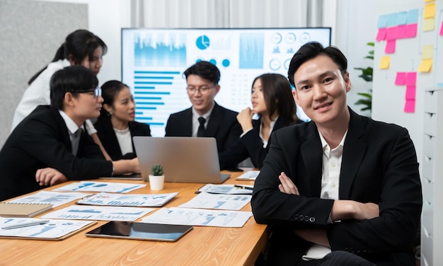 Focus portrait male manager in harmony office with businesspeople in background