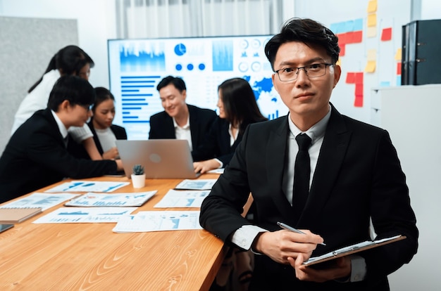 Focus portrait male manager in harmony office with businesspeople in background