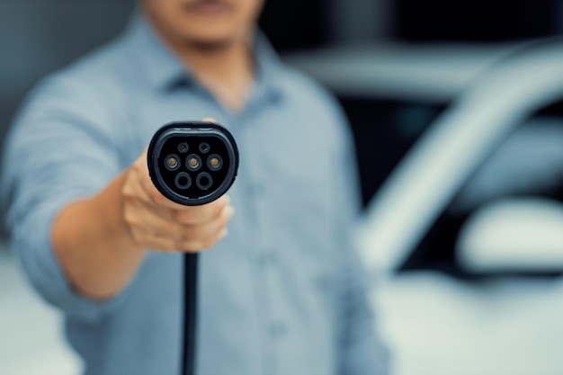 Focus progressive EV charger device pointing at camera with blur background