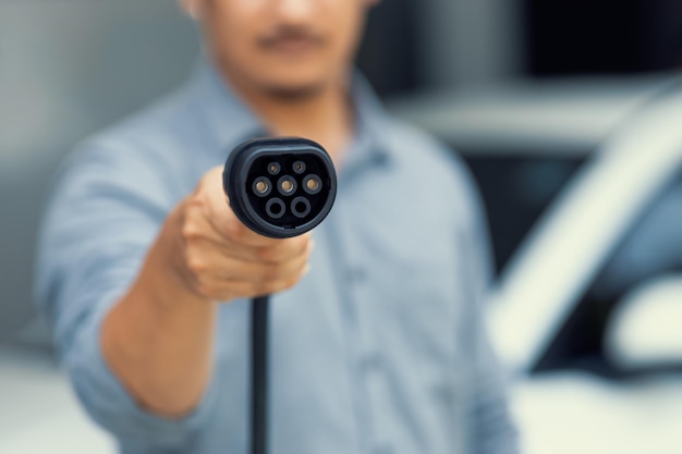 Focus progressive EV charger device pointing at camera with blur background