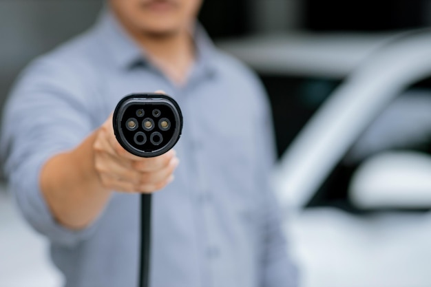 Focus progressive EV charger device pointing at camera with blur background