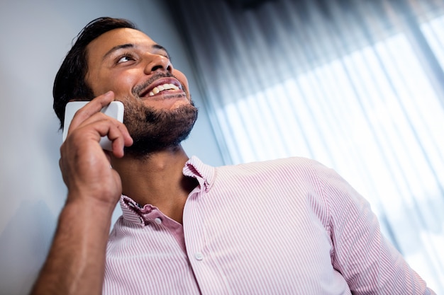 Focus on smiling businessman calling with smartphone