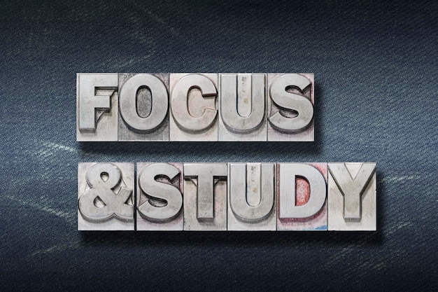 Focus and study phrase made from metallic letterpress on dark jeans background