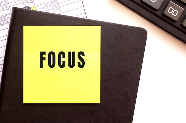 Focus testo su un adesivo sul desktop. diario e calcolatrice.