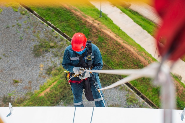 Focus top view male worker down height tank roof knot handrail\
rope access safety inspection of thickness storage tank roof gas\
propane.