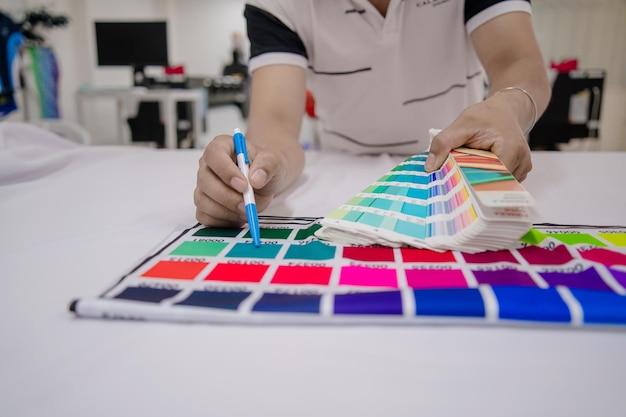 Photo focus young asian man wearing medical mask hand holding a color palette sample of different colors