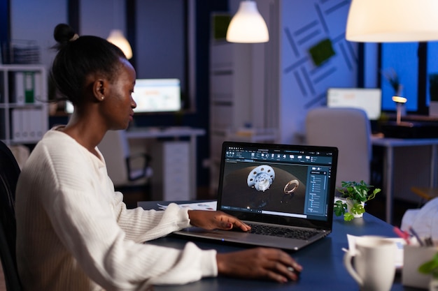 Focused african american engineer woman working at industrial gear prototype