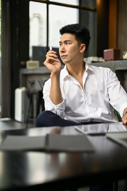 Focused Asian businessman planning his project while sitting in a coffee shop