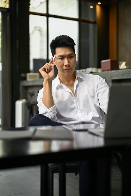 Focused Asian businessman planning his project while sitting in a coffee shop