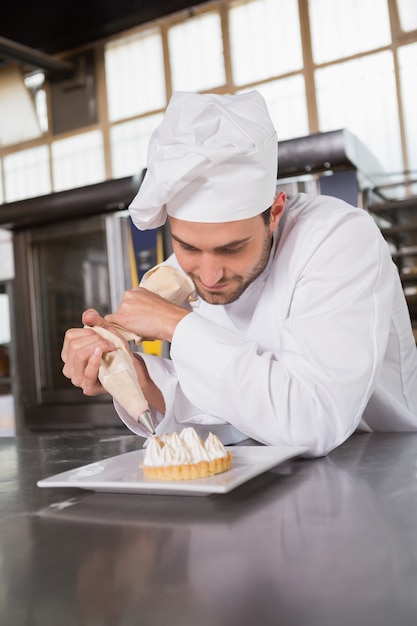 Focused baker preparing handmade cake