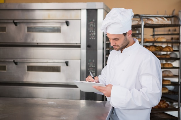 Panettiere messo a fuoco che scrive sulla lavagna per appunti