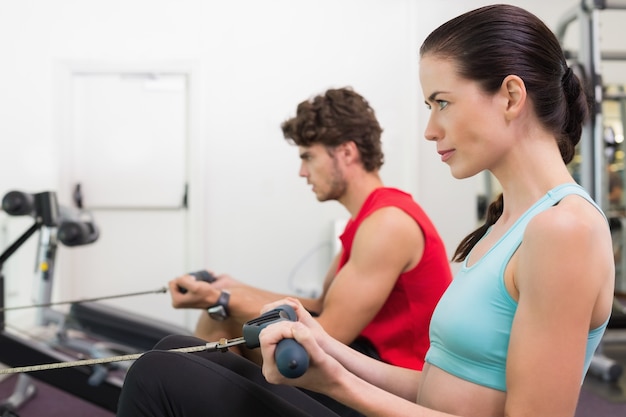 Focused brunette working out on the rowing machine