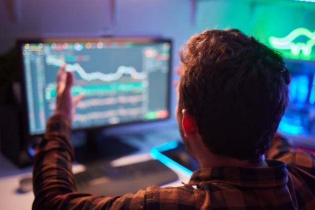Сосредоточенный бизнесмен-аналитик-трейдер смотрит на монитор компьютера, инвестор-брокер анализирует индексы