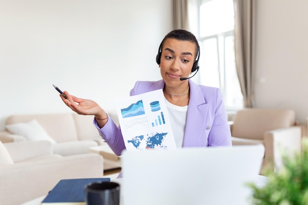 Focused business woman presenting charts and graphs on video call online Young business woman having conference call with client on laptop Young woman explaining how business work