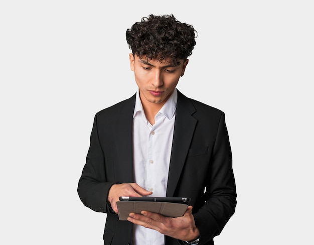 Focused businessman holding a tablet with a serious expression