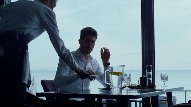 Focused businessman spending time break in luxury panoramic restaurant