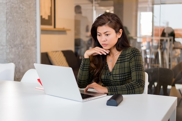 Photo focused businesswoman browsing laptop in office