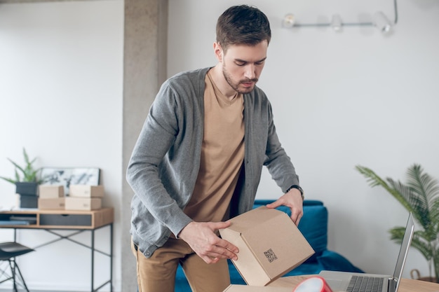 Focused calm employee packing wares for shipping