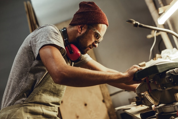 Photo focused carpenter working with circular saw