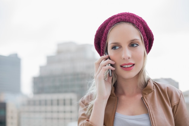 Focused casual blonde on the phone outdoors