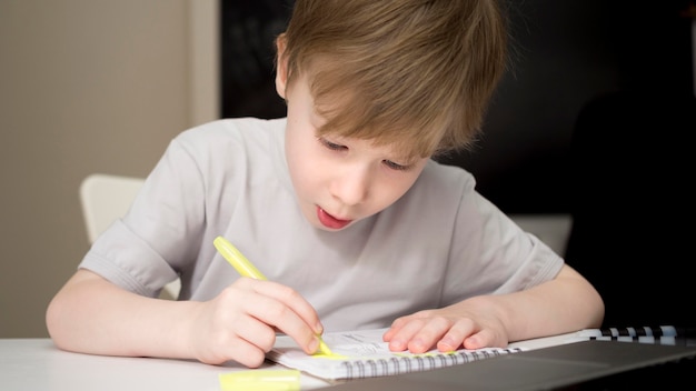 Сосредоточенный ребенок пишет в своей тетради