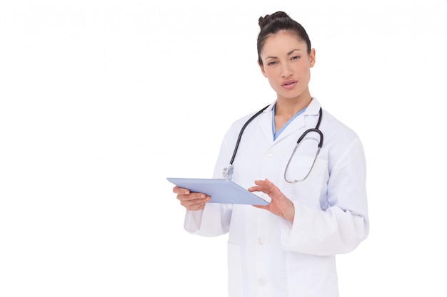 Focused doctor using her tablet pc