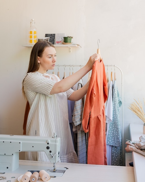 Focused female owner of local clothing business with newly sewn dress