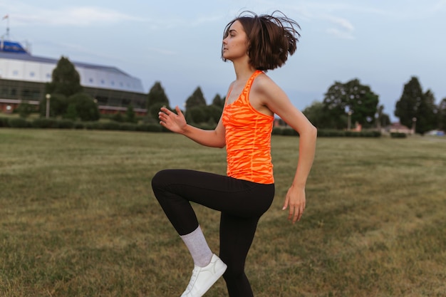 focused female runner running in place and doing cardio exercise