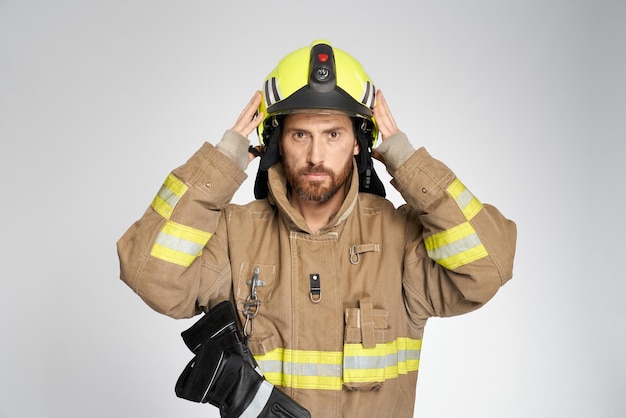 Focused firefighter putting on yellow helmet before working shift