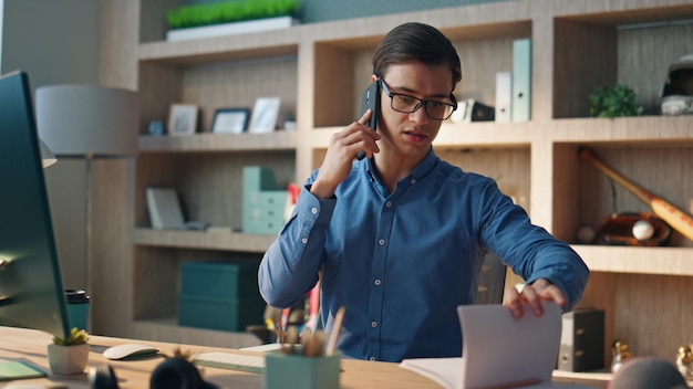 Focused freelancer chatting mobile phone at office closeup creator having call