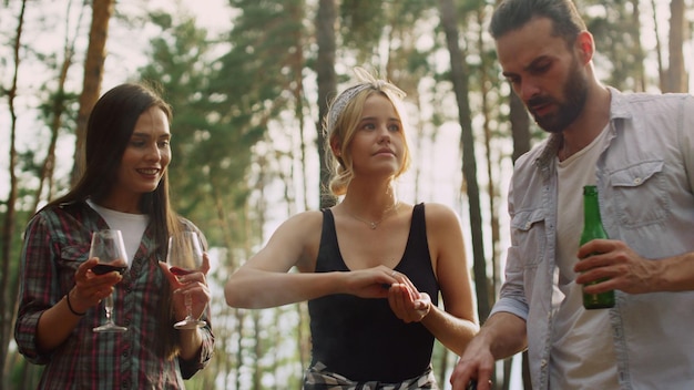 Focused friends cooking food together outside Smiling woman keeping salt