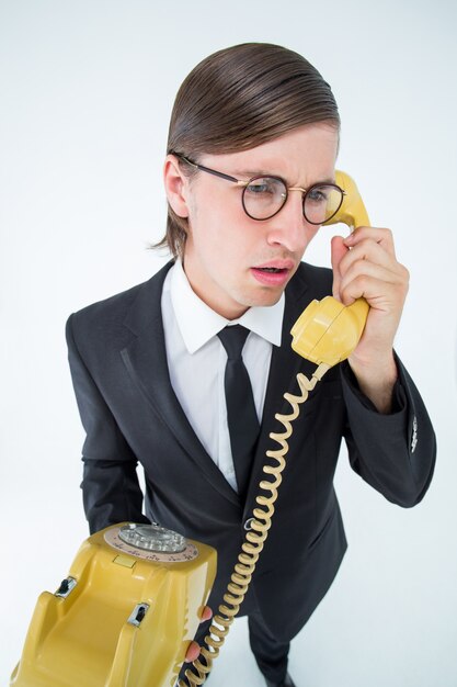 Сосредоточенный geeky бизнесмен по телефону
