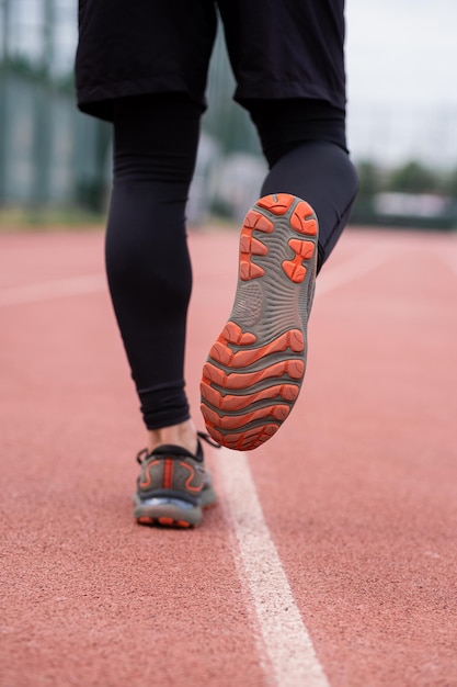 Focused jogger benen in comfortabele sneakers races running track op een stedelijk stadion