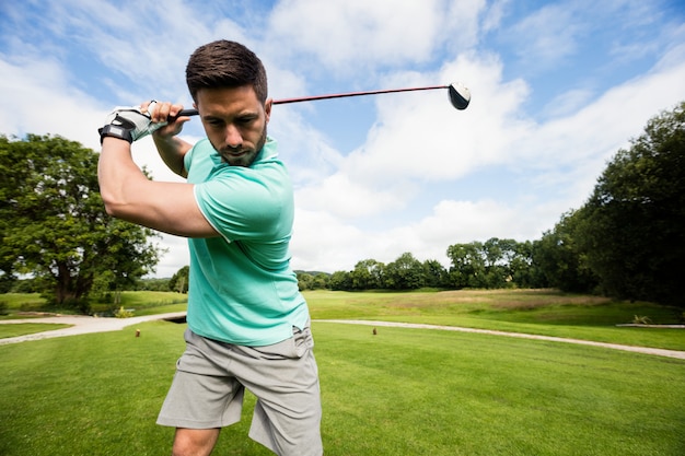 Uomo concentrato che gioca a golf