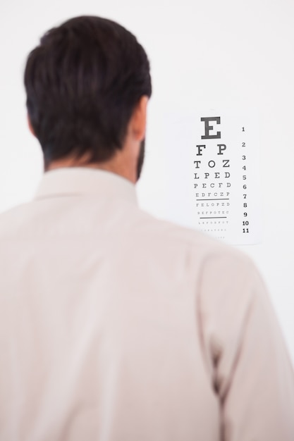 Photo focused man in suit on eye test letters