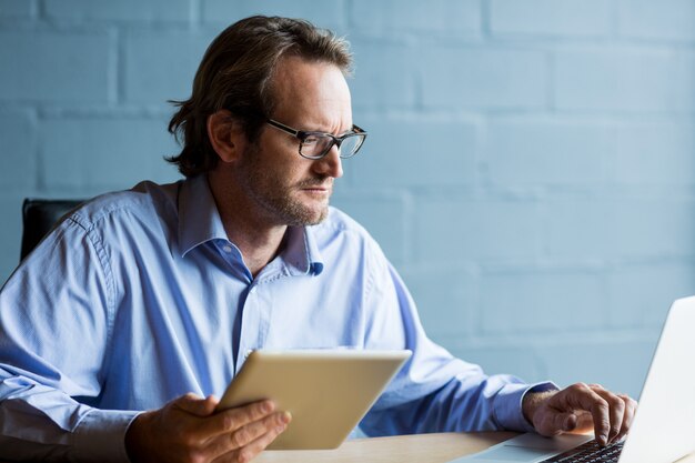 Focused man using laptop in office