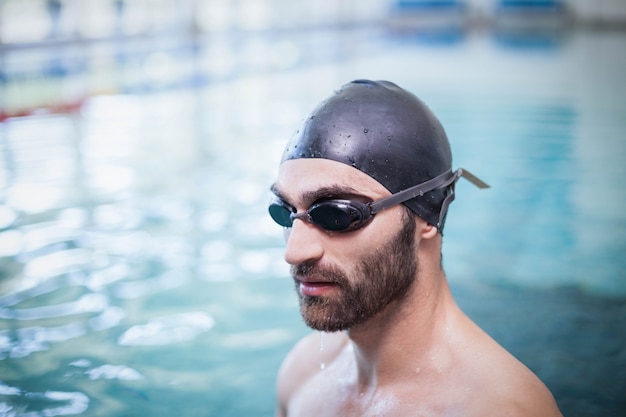 Focused man wearing swim cap and goggles at the pool