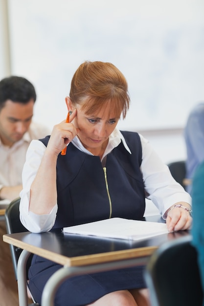 Focused mature student sitting in classroom 