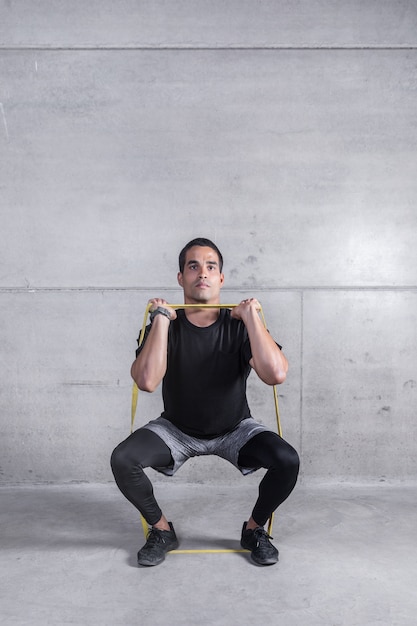 Focused personal trainer doing exercise with elastic band