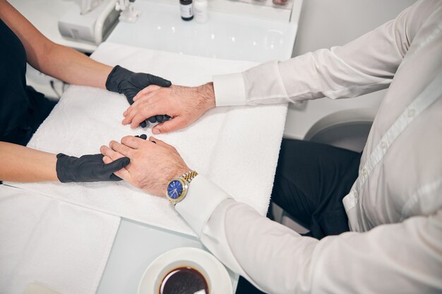 Focused photo on young man sitting in semi position and waiting for beauty procedure