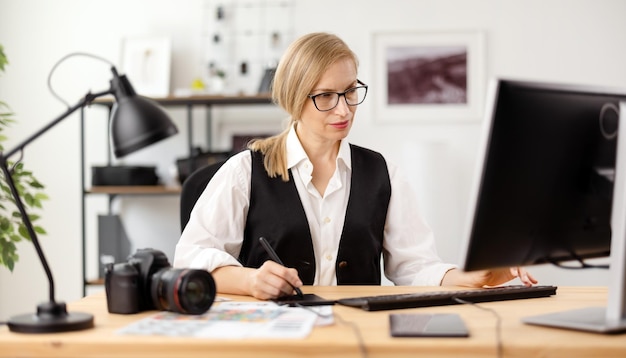 Focused photographer in eyeglasses sitting at