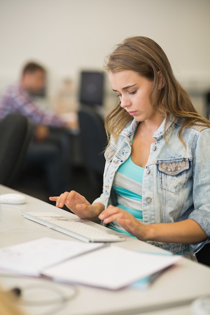 Foto concentrato studente carino che lavora nella sala computer