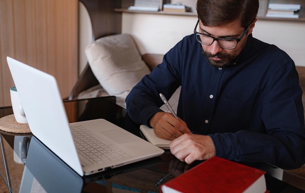 Focused serious male student using laptop looking at computer screen